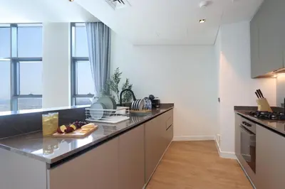 a kitchen with a counter top and some windows at Chic 1B by Dubai Canal Marasi Drive with Pool, Gym in Dubai