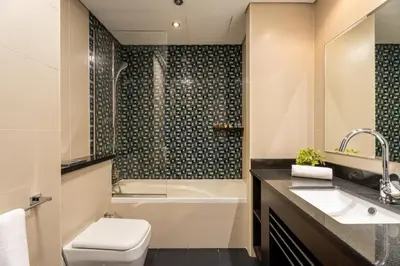 a bathroom with a toilet and a tub and a sink at GuestReady - Spectacular Marina Views | High Floor in Dubai