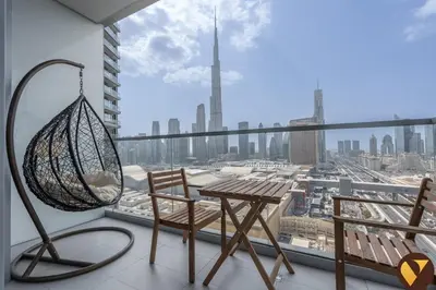 a balcony with a table and chairs and a view of a city at Vogue Downtown Vida Dubai Mall, Direct Access to Dubai Mall via Climate Controlled bridge, Two Bedroom Apartment with Full Burj Khalifa View from Balcony and Access to all Amenities in Dubai