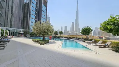 a swimming pool in a city with buildings at Vogue Downtown Vida Dubai Mall, Direct Access to Dubai Mall via Climate Controlled bridge, Two Bedroom Apartment with Full Burj Khalifa View from Balcony and Access to all Amenities in Dubai