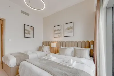 two beds in a bedroom with white walls at Highest floor - 5 mins walk to Dubai Mall and Burj Khalifa in Dubai