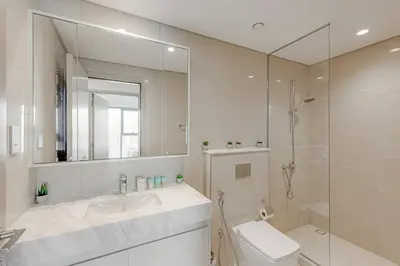 a white bathroom with a sink and a shower at Highest floor - 5 mins walk to Dubai Mall and Burj Khalifa in Dubai