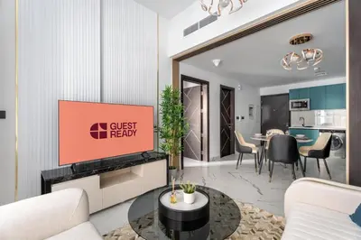 a living room with a tv and a dining room at GuestReady - Spacious 1Bed l Near Butterfly Garden in Dubai