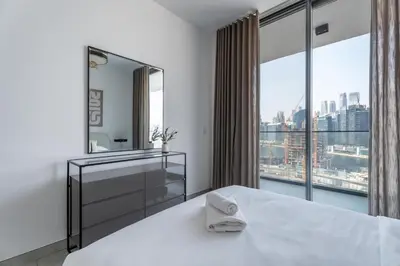 a bedroom with a large window and a bed with a mirror at GuestReady - Dubai Skyline & Canal View | 1 BHK in Dubai