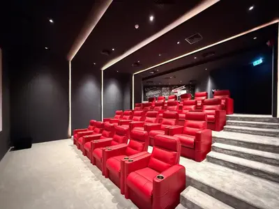 a theatre with red chairs and stairs in it at GuestReady - Dubai Skyline & Canal View | 1 BHK in Dubai