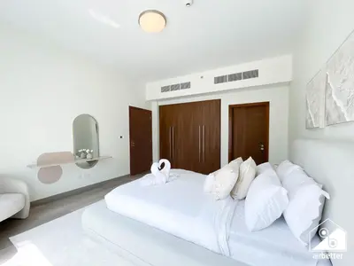 a white bedroom with a large white bed with white pillows at Luxurious 1BR with Balcony & Premium Stay in Downtown in Dubai