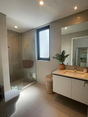 a bathroom with a sink and a toilet and a mirror at Bright & Stylish 4BR Villa in Dubai