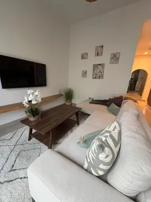 a living room with a white couch and a tv at Bright & Stylish 4BR Villa in Dubai