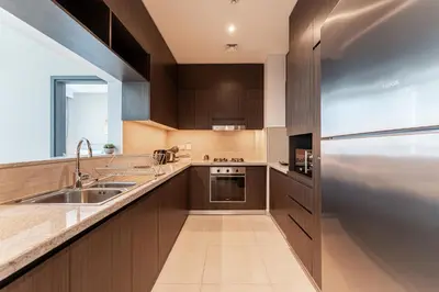 a kitchen with a sink and a refrigerator at HAVN - 2 bedroom in Downtown Views Dubai in Dubai