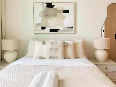 a bedroom with a white bed with two lamps at Stylish High-Floor Studio in Binghatti Azure! in Dubai