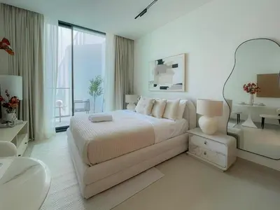 a white bedroom with a large bed and a window at Stylish High-Floor Studio in Binghatti Azure! in Dubai