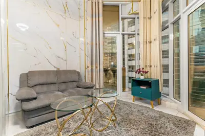 a living room with a couch and a glass table at FIRST CLASS Studio Cozy Marble Elegance in Dubai