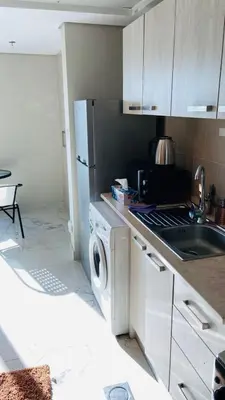 a kitchen with a refrigerator and a washing machine at Studio in May 5 Boulevard in Dubai