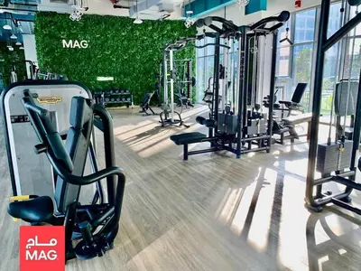 a gym with many treadmills and machines in it at Studio in May 5 Boulevard in Dubai