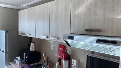 a kitchen with wooden cabinets and a microwave at Studio in May 5 Boulevard in Dubai