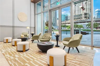 a lobby with chairs and tables and large windows at FIRST CLASS 1BR Burj Khalifa & Skyline Views in Dubai