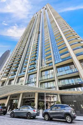 two cars parked in front of a large building at FIRST CLASS 1BR Burj Khalifa & Skyline Views in Dubai