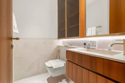 a bathroom with a toilet and a sink and a mirror at FIRST CLASS 4BR Elegant Beach House Retreat in Dubai