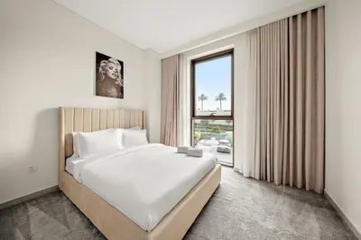 a bedroom with a large bed and a large window at FIRST CLASS 1BR Creek Beach & Lagoon Escape in Dubai