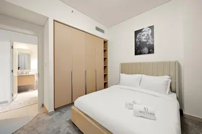 a bedroom with a large bed and a closet at FIRST CLASS 1BR Creek Beach & Lagoon Escape in Dubai