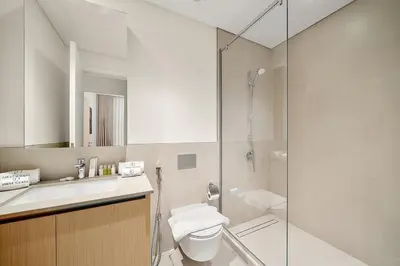 a bathroom with a shower and a toilet and a sink at FIRST CLASS 1BR Creek Beach & Lagoon Escape in Dubai