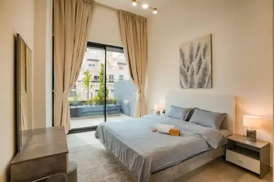 a bedroom with a large bed and a large window at Apartment in Binghatti Crescent, Next to Circle Mall in Dubai