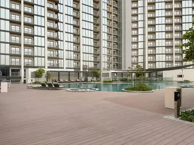 a large building with a swimming pool in front of it at FIRST CLASS 3BR Luxury Meets Tranquility in Dubai