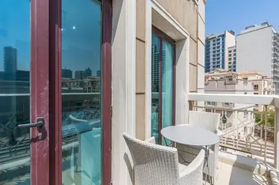 a table and chairs on a balcony with a view of a city at Chic Studio in JVC near Butterfly and Miracle Garden in Dubai