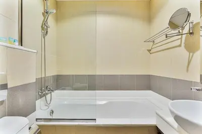 a bathroom with a tub and a toilet and a sink at Chic Studio in JVC near Butterfly and Miracle Garden in Dubai