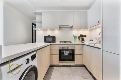 a kitchen with a washer and dryer in it at Bookable 2 Bed Crest Sobha Hartland with Burj view in Dubai
