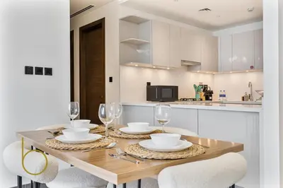 a dining room table with glasses and plates on it at Bookable 2 Bed Crest Sobha Hartland with Burj view in Dubai