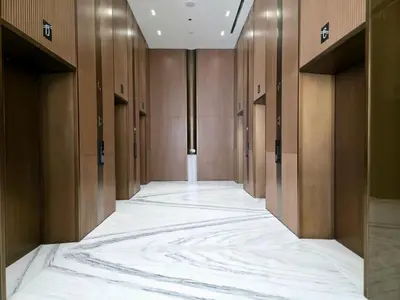 an empty hallway with a large white marble floor at Royalton - Modern JVC Studio Escape in Dubai