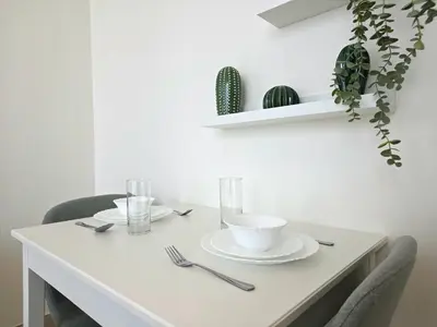 a white table with two chairs and a white plate at Royalton - Modern JVC Studio Escape in Dubai