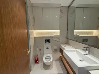 a bathroom with a toilet and a sink and a mirror at Azizi 205 Fully Furnished Apartment in Dubai