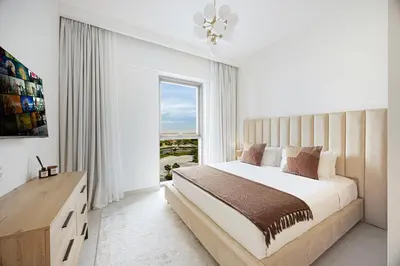 a white bedroom with a large bed and a window at Daniels 1BR at Bayshore 4 Creek Beach in Dubai