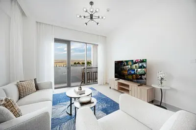 a living room with white furniture and a tv at Daniels 1BR at Bayshore 4 Creek Beach in Dubai