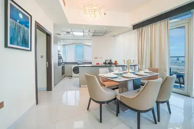 a dining room and kitchen with a table and chairs at EasyGo - Elegant 2 Bedroom near Miracle Garden in Dubai