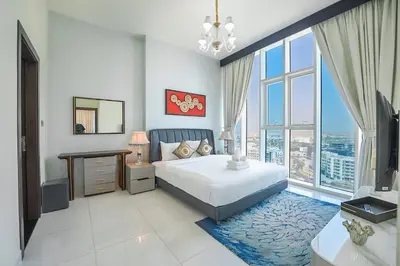 a bedroom with a bed and a large window at EasyGo - Elegant 2 Bedroom near Miracle Garden in Dubai