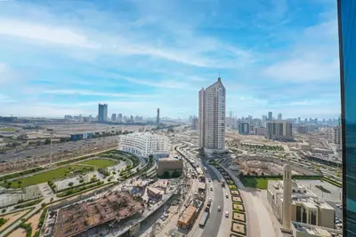 a view of a busy city with a tall building at EasyGo - Elegant 2 Bedroom near Miracle Garden in Dubai