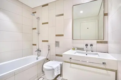a bathroom with a sink and a toilet and a mirror at Beach Vista - Stunning Sea View in Dubai