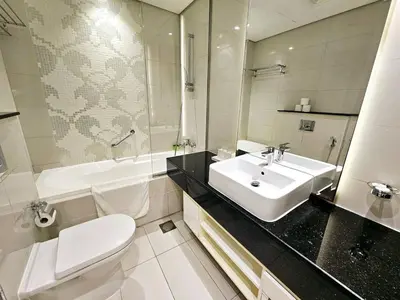 a bathroom with a sink and a toilet and a tub at Chic Studio close to Dubai Mall with Canal Views in Dubai