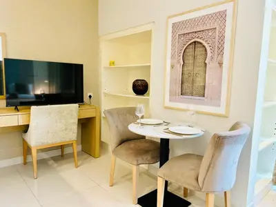a dining room with a table and chairs and a television at Chic Studio close to Dubai Mall with Canal Views in Dubai
