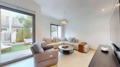 a living room with a couch and a table at Vacationer l Luxury Comfort 2 Bed Villa with Garden & Garage I Motor City in Dubai