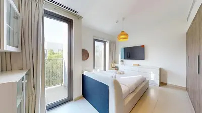 a living room with a couch and a large window at Vacationer l Luxury Comfort 2 Bed Villa with Garden & Garage I Motor City in Dubai