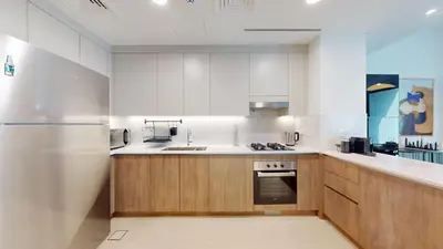 a kitchen with wooden cabinets and a stainless steel refrigerator at Vacationer l Luxury Comfort 2 Bed Villa with Garden & Garage I Motor City in Dubai