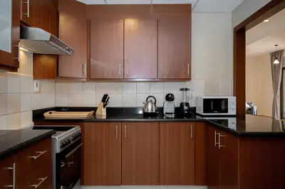 a kitchen with wooden cabinets and a stove top oven at HiGuests - Fancy 1BR Apt With Aerial Marina Views in JBR in Dubai