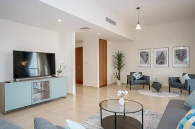 a living room with a tv and a couch and chairs at HiGuests - Fancy 1BR Apt With Aerial Marina Views in JBR in Dubai