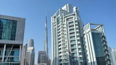 a tall building in the middle of a city at DAMAC - Bays Edge 1BR - Burj Khalifa Views & Pool in Dubai
