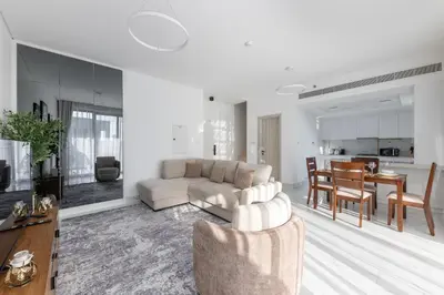 a living room with a couch and a dining room at Brand New Grand 2BR Duplex apartment in Jumeirah Village Circle with Pool, Gym and kids playground in Dubai