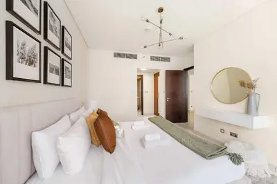 a living room with a white couch and a mirror at Silkhaus Luxurious 1BR at Sky Gardens in DIFC in Dubai